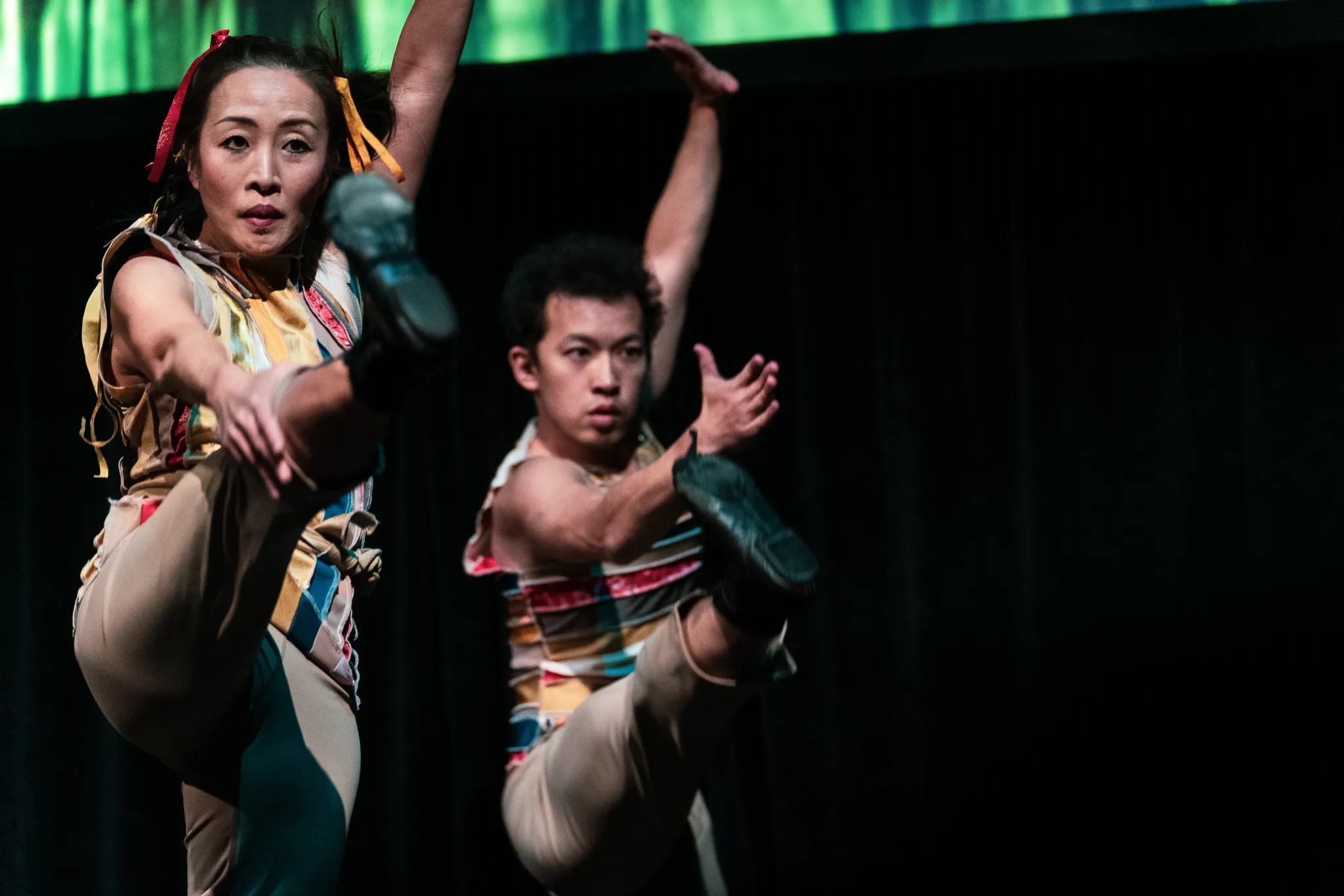 Two dancers kicking forward in unison