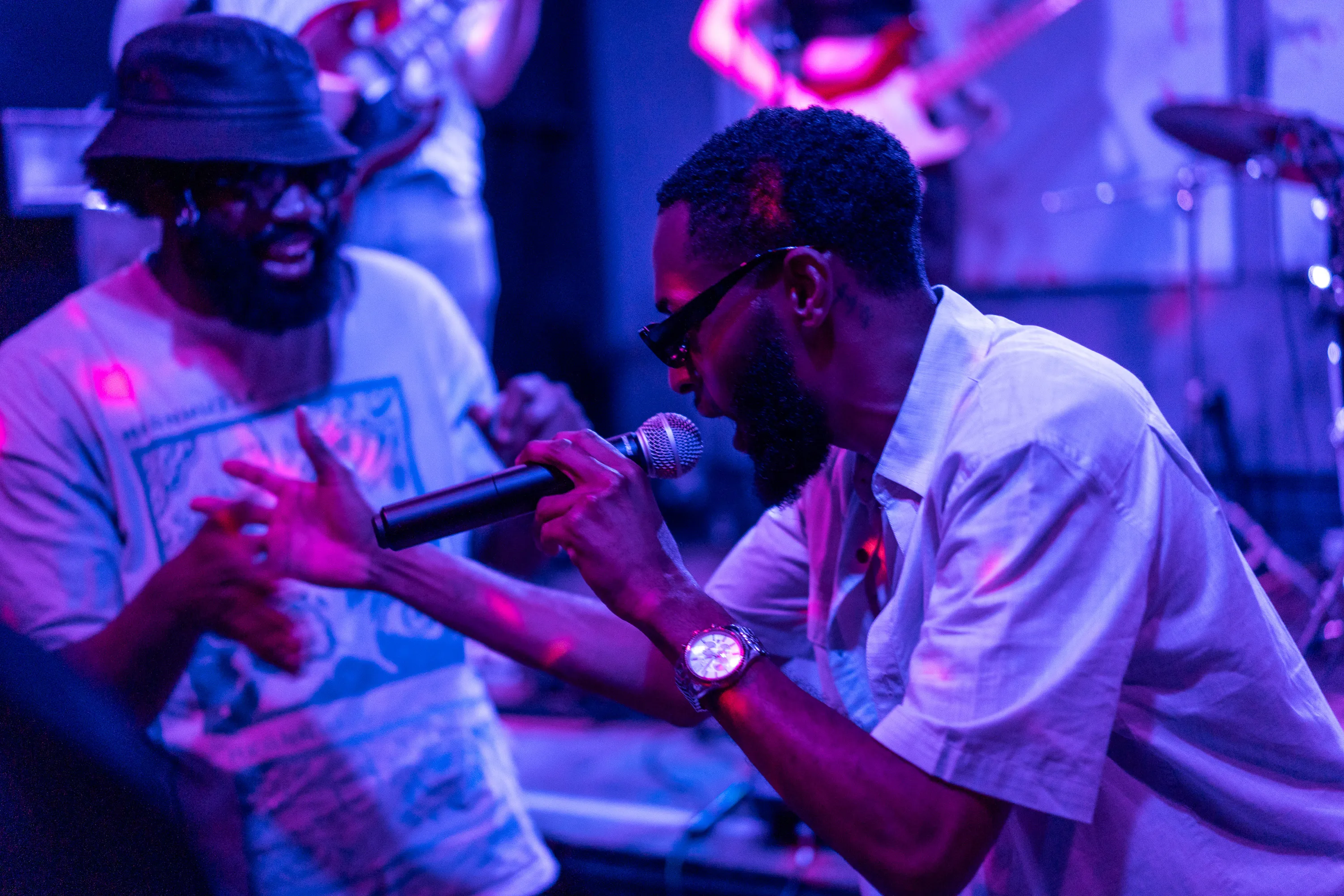 A vocalist leaning toward an audience member and reaching out his hand