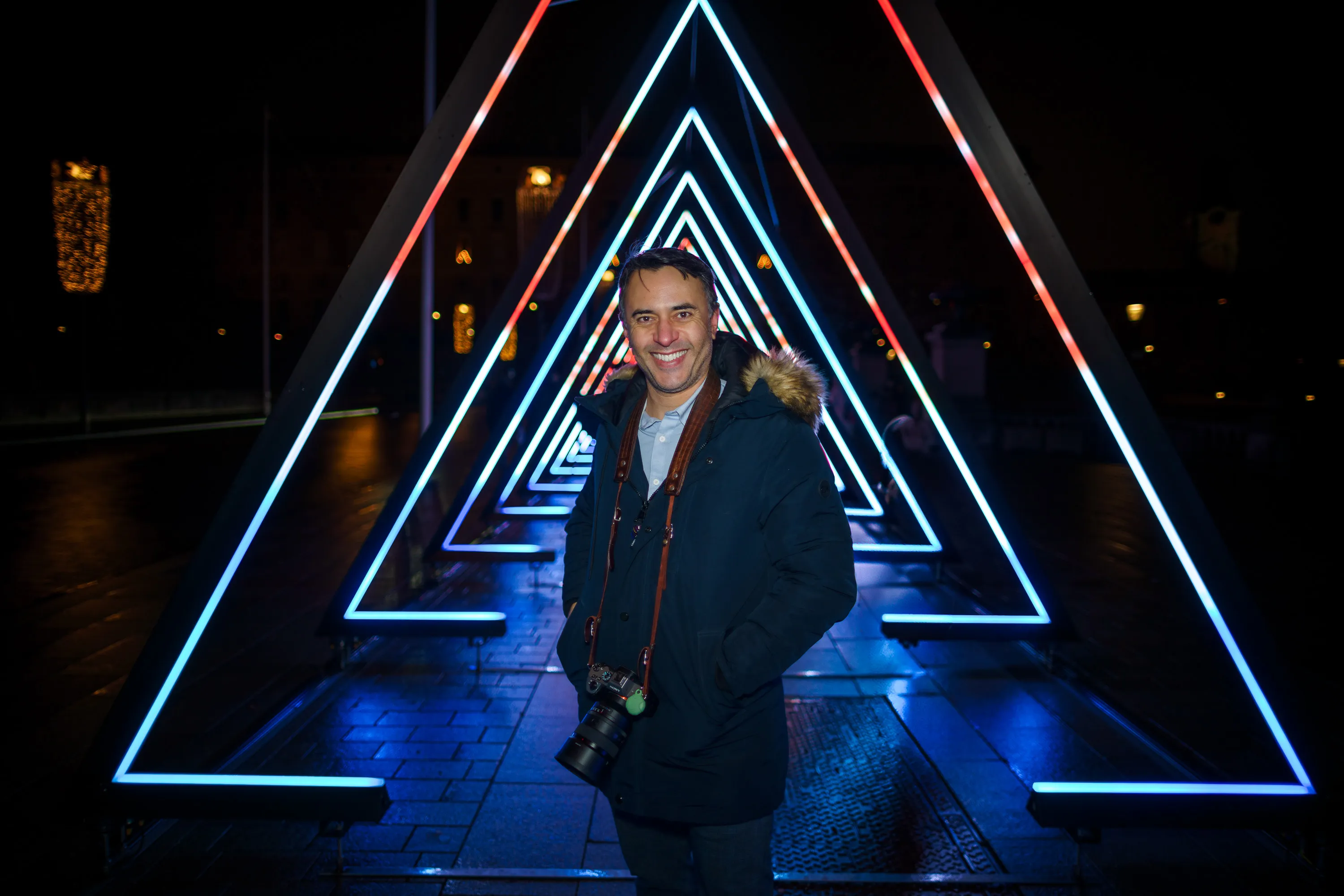 A photographer beneath illuminated arches in Stockholm